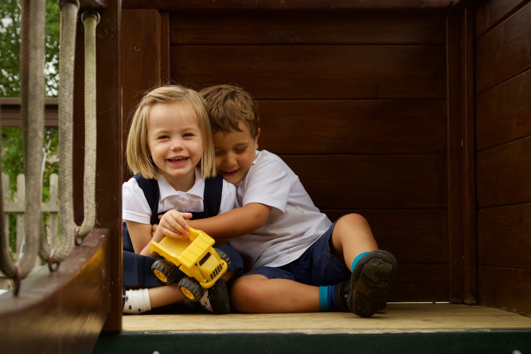Boy hugging girl and smiling in the garden at Mount Carmel Kindergarten